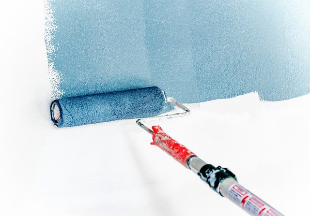 Paint roller painting a wall