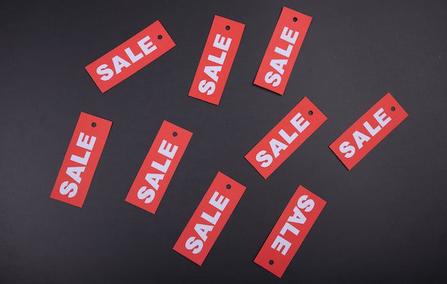 Red sale signs on a black surface