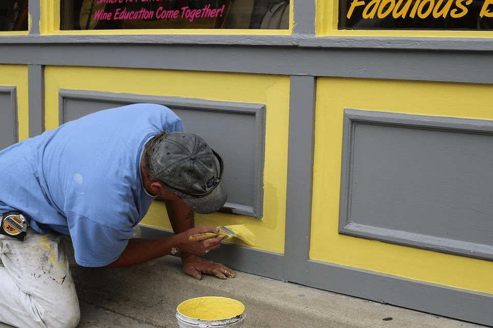 A man painting the details of a wall