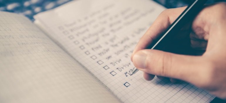 A person writing down a safety protocol checklist
